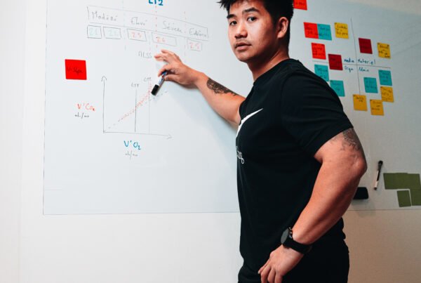 Homme au tableau qui explique des graphiques liés à la physiologie de l'entraînement