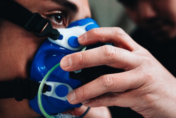 Homme qui place un masque d'analyse d'échange gazeux sur une femme